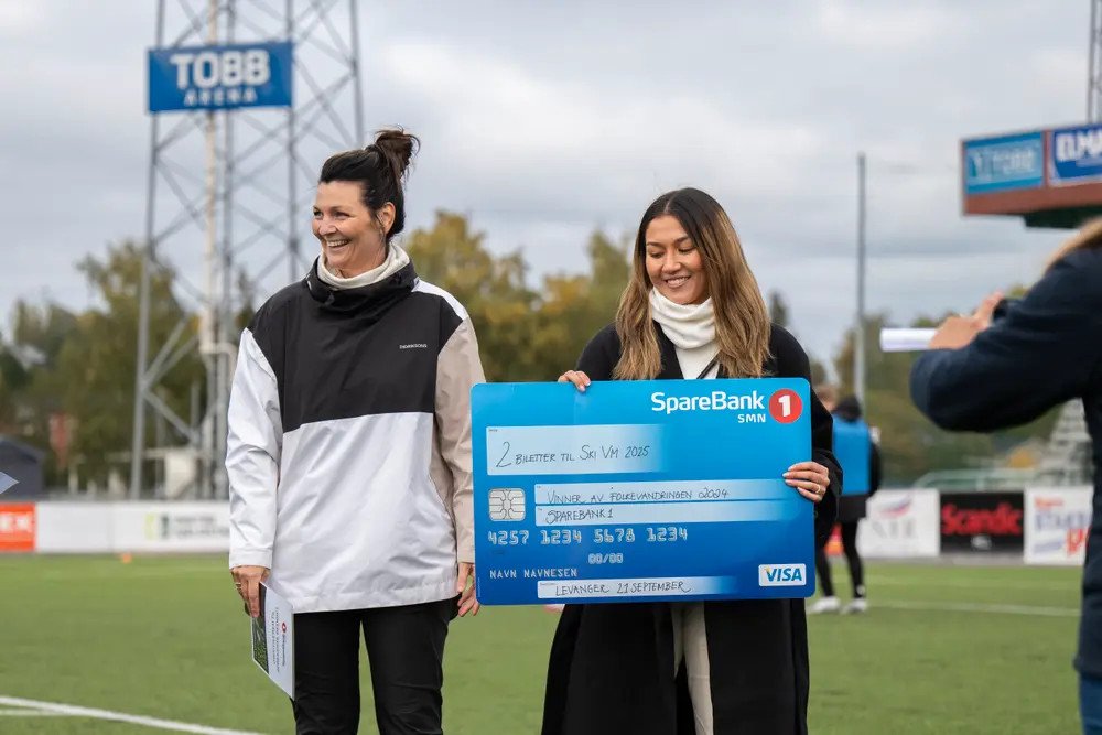 Her får Anne Maria Andresen utdelt det synlige beviset på at hun gikk helt til topps i konkurransen. Til venstre banksjef i Sparebank 1 SMN, Marit Jørpeland. Foto: Eirik Reinaas Bjørshol